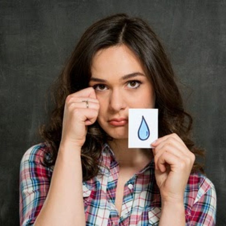 Young Woman Holding Paper With Tears Drawn On It