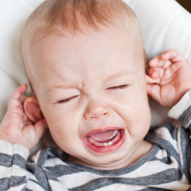23379355 - cute little boy crying and holding his ear on a white background