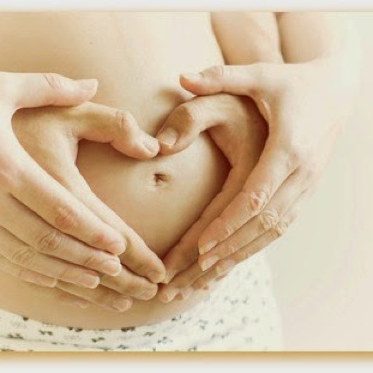 Couple hand make heart symbol on the pregnant wife stomach